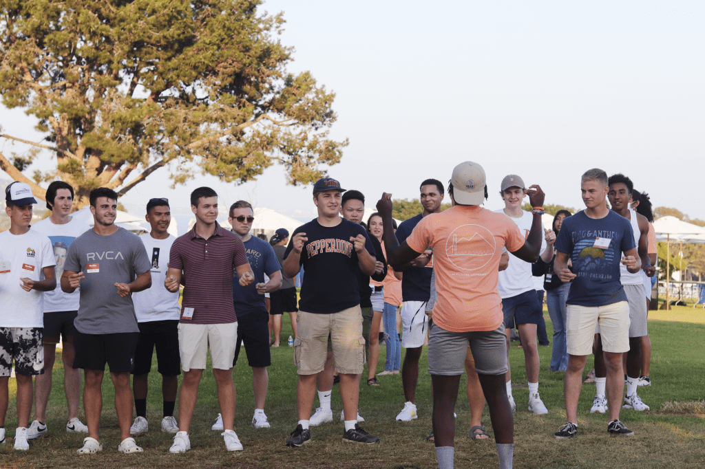Rockwell Towers resident adviser Timothy Jackson snaps along as he leads the opening section for the group's Soph Follies skit Aug. 21 at Alumni Park. The Year 2 Welcome offered traditions like Soph Follies that sophomores missed out on last year. Photo by Ali Levens