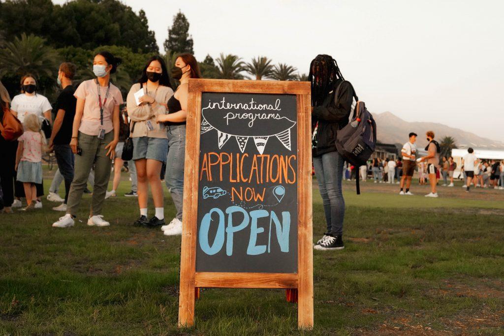 A sign at the Return on Alumni Park reads "Applications Now Open." Applications for academic year 2022-23 and summer 2022 programs have a priority deadline of Sept. 27.