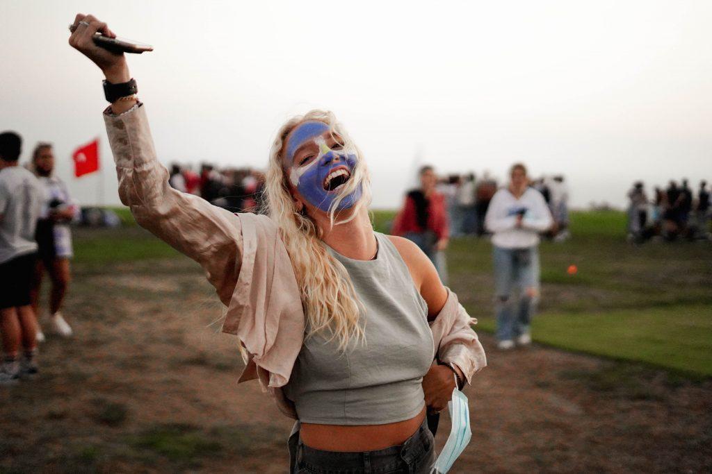 Sophomore Courtney Wisniewski smiles at the camera with her face painted with the Argentine flag. Although the Return was mainly for first-year students and IP alumni, some sophomores and juniors also attended the event in support.