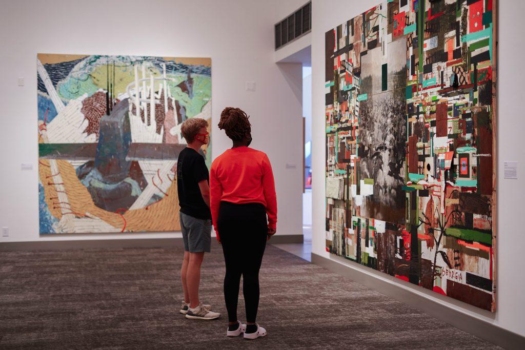 Two students view an "Environmental Reflections" piece at the Weisman Museum. Students can access the exhibit for free, but they must reserve timed-entry tickets from the museum&squot;s website. Photo by Dane Bruhahn