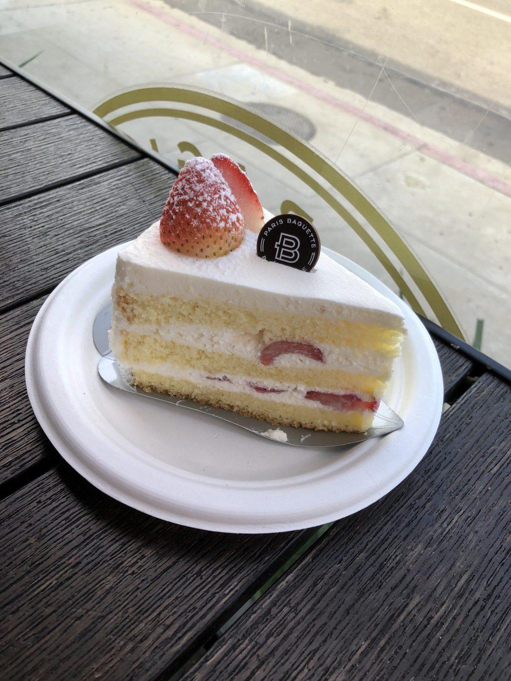 A slice of strawberry soft cream cake sits on a table. My parents bought me this cake every year for my birthday.