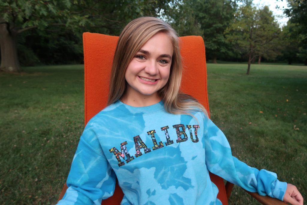 Mentzer poses in her embroidered "Malibu" sweatshirt in Dayton, Ohio in fall 2020. Mentzer&squot;s business took off when Candace Cameron Bure from "Full House" posted her sweatshirts on Instagram. Photo courtesy of Myers Mentzer