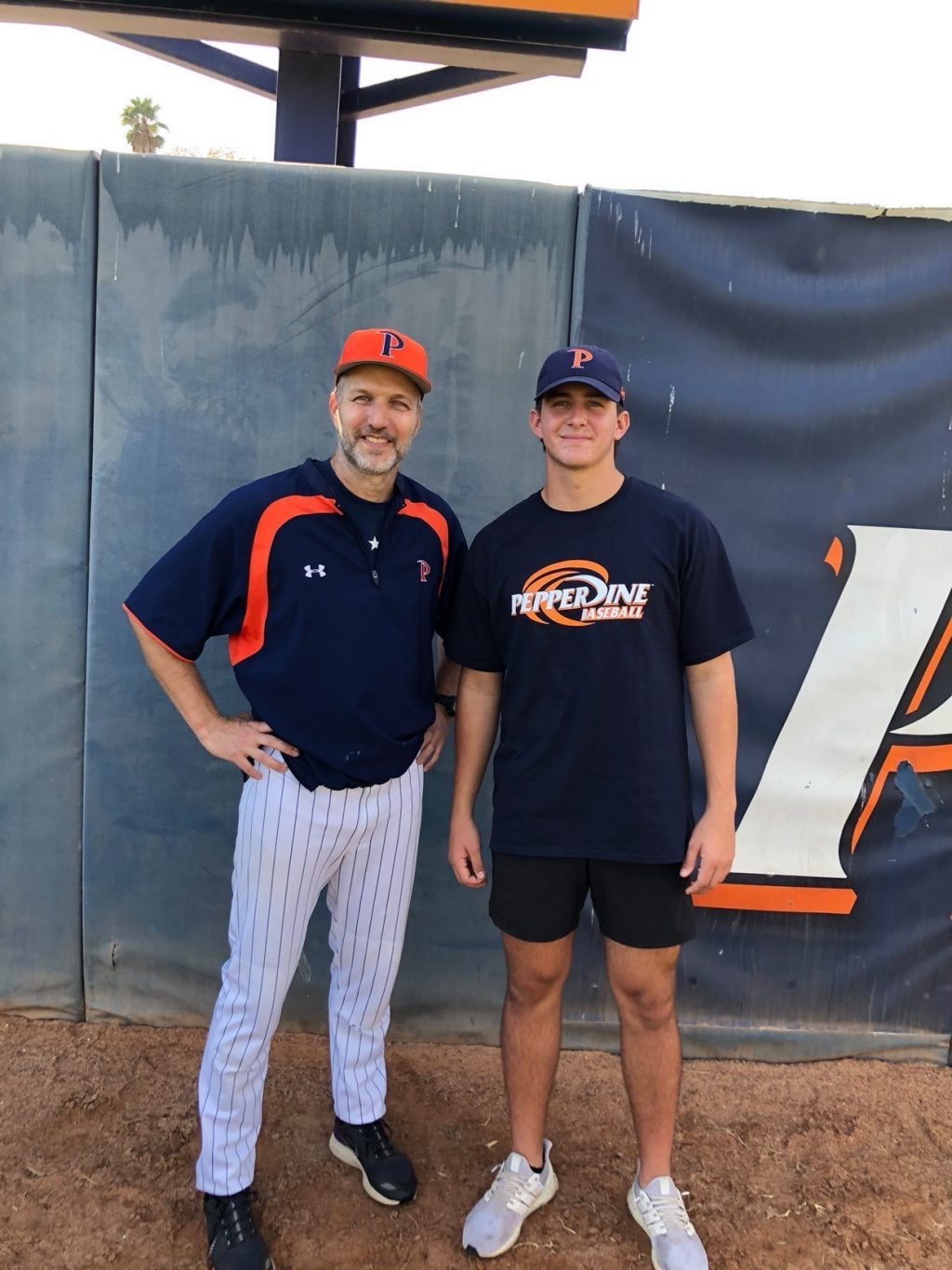 Volunteer baseball coach Patrick Ahearne and Adam Troy pose for a picture the first day of the Pepperdine baseball recruitment camp. Ahearne is a long-time friend of Troy's dad, which led to his desire to play baseball for Pepperdine. Photo Courtesy of Adam Troy