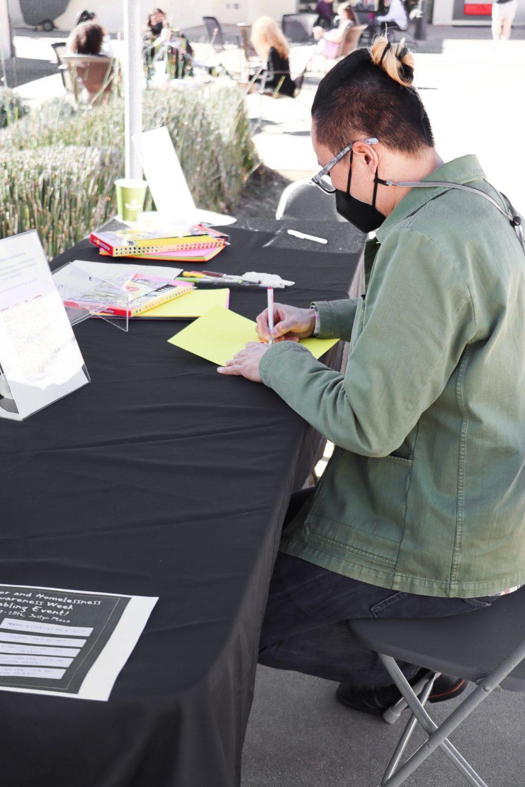 Associate Chaplain Zac Luben writes encouraging notes to the insecure housing community of Los Angeles. To personalize the kits, students wrote Bible verses and inspiring statements on note cards to add to the bags.