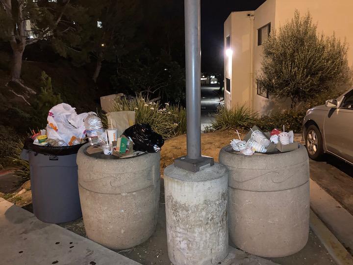 Trash accumulates in Rho parking lot on a Saturday night in fall 2021. In 2019, there used to be only one trash can, and with fewer available custodians and more residents, even the extra trash cans overflowed.