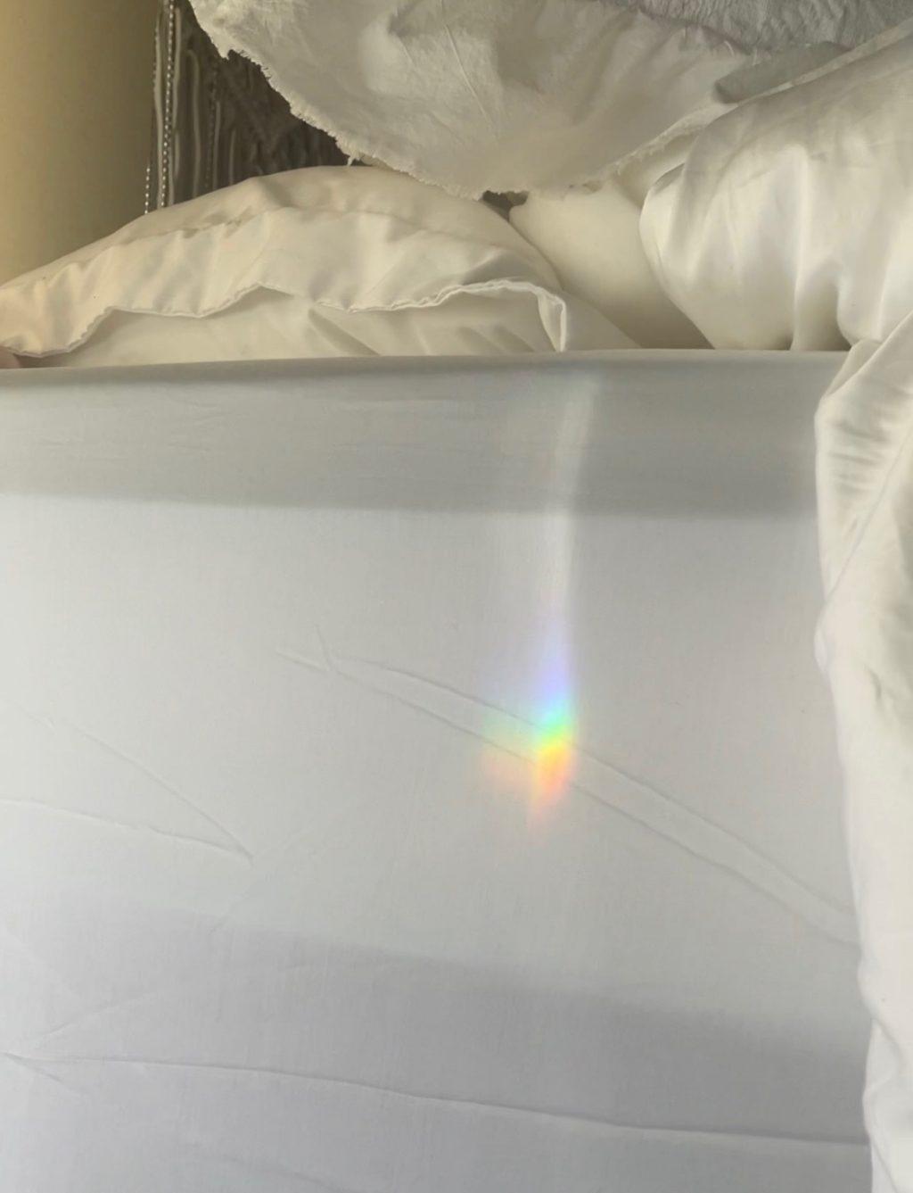 A bright rainbow shines on the sheets of the bed after Russell comes home from an NSO event. Russell's roommate, first-year Holi Orefice, found the rainbow.