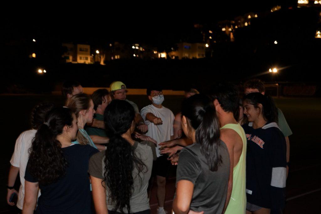 Members of Running Club come together for a pep-talk before running on the University track. Senior Rogan Rongley said he appreciated the way running club supported him in getting back into running after taking a long break.