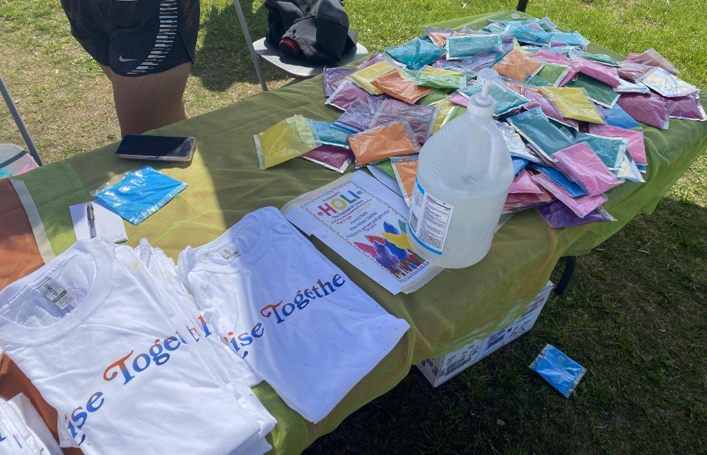 At the entrance of the festival, ISA e-board members pass out colored powders and white RISE t-shirts to students. Wearing white and throwing colored powder are symbolic practices of the Holi festival. Photo by Christina Buravtsova