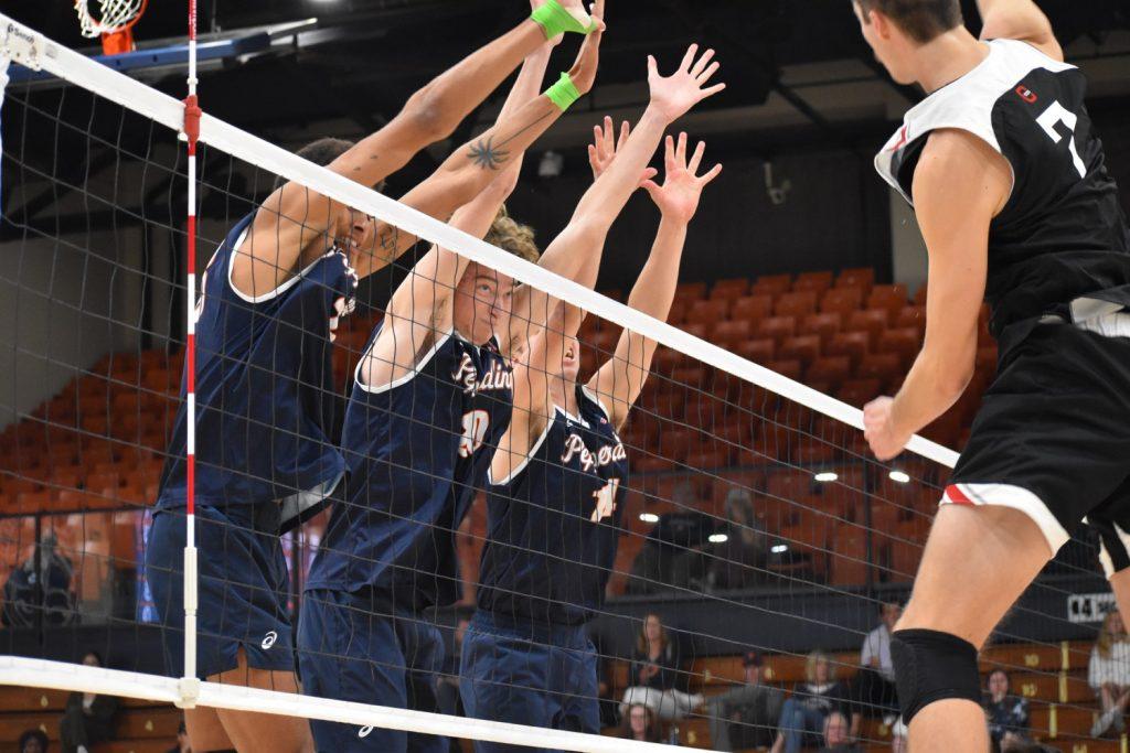 Gettinger joins graduate student middle blocker Austin Wilmot and graduate student outside hitter Jaylen Jasper for a triple block. The Waves finished the game with thirteen team blocks. Photo by Mary Elisabeth