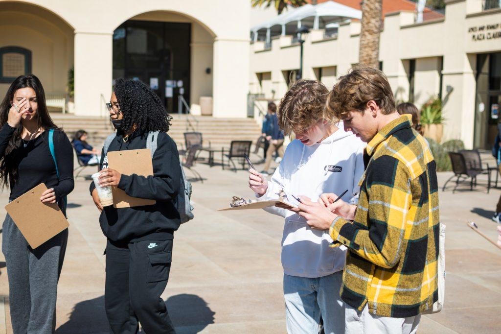 Students fill out the disordered-eating screener at the SWAB table on Lower Adamson Plaza. Junior Healthy Communities ambassador Mallory Finley said it is important for college students to be aware of their healthy habits. Photo by Lucian Himes