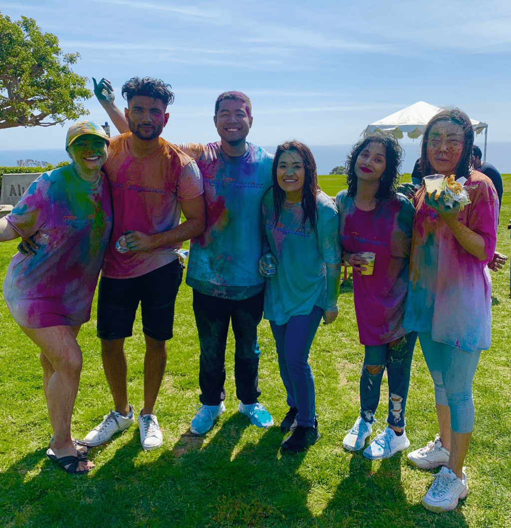 Festival attendees take a break from the color fights to enjoy some butter chicken burritos with a cup of mango lassi. From the colored powder to food, students said they had a chance to fully immerse themselves in Indian culture. Photo courtesy of Mimi Dao