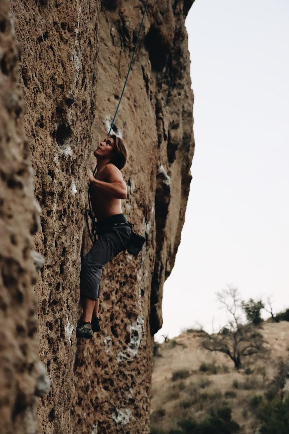 Fifth-year Climbing Club Vice President Jeremiah Jones ascends a rock face while top-rope climbing in Malibu Creek State Park in Nov., 2021. Jones and other members said they enjoy climbing outdoors more than in a gym. Photo by Sammie Wuensche