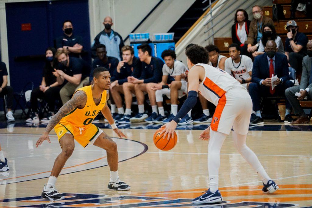 Freshman guard Mike Mitchell Jr. faces off with a USF player on Jan. 22 at Firestone Fieldhouse. The Waves lost this game, but Mitchell and freshman center Carson Basham hit double digits scoring — Basham's first game hitting double digits in his college career. Photo by Gabrielle Salgado