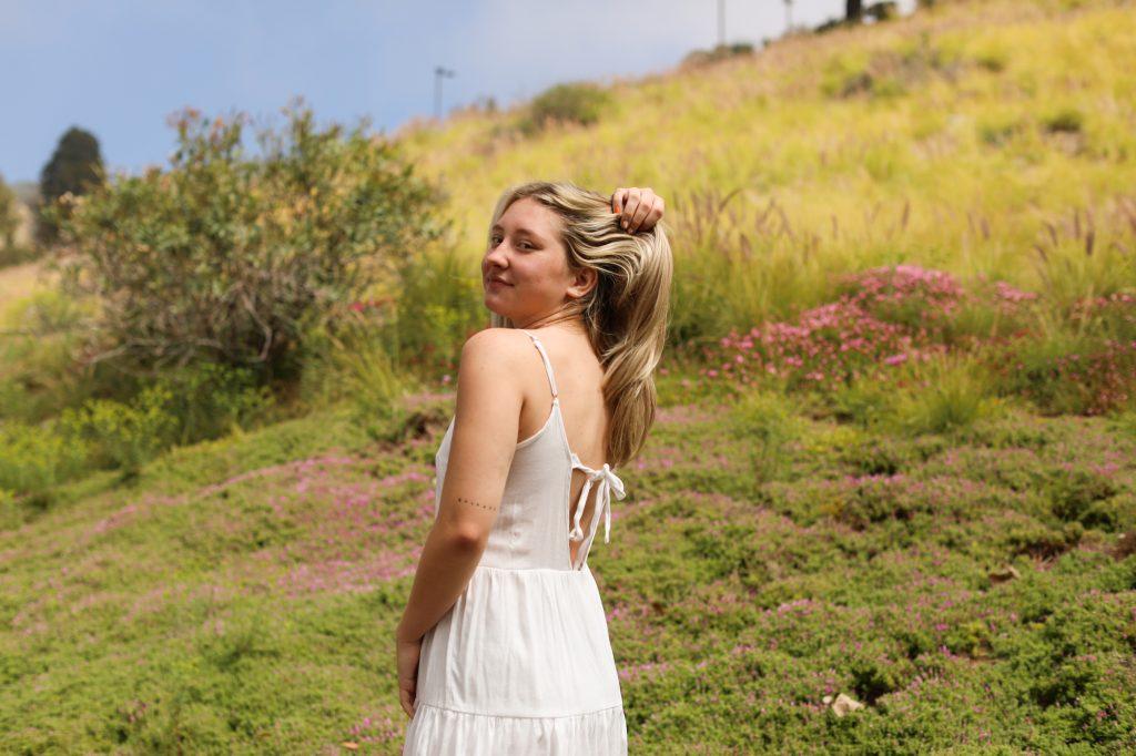 Photo by Caroline Conder | Destin Kvidera, senior Integrated Marketing Communication major, stood among the wildflowers on Lower Dorm Road. Kvidera has Type 1 diabetes and psoriatic arthritis and identifies as a queer, disabled woman.