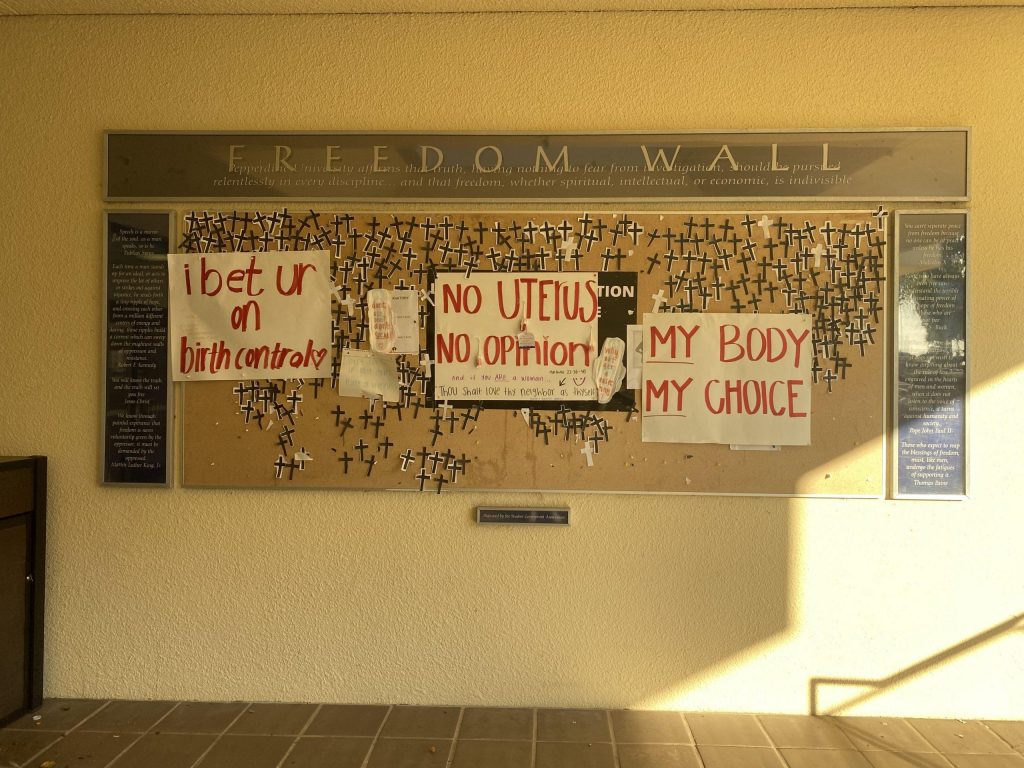 Within days after the initial posting, new abortion-rights signs hang on the Freedom Wall on Sept. 29. Students also removed crosses from the wall. Photo by Samantha Torre.