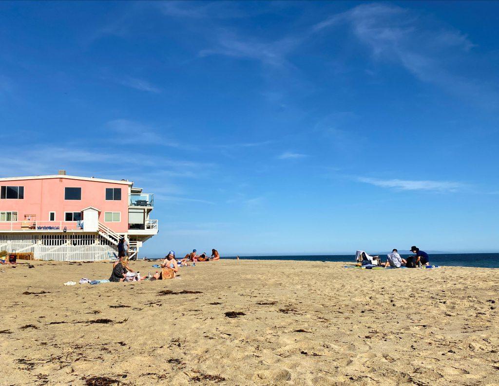 Beachgoers lounge on Dead End Beach beside the infamous pink house. The beach was unofficially named "Ralphs Beach" by Pepperdine students due to its proximity to Ralph&squot;s supermarket location in Malibu.