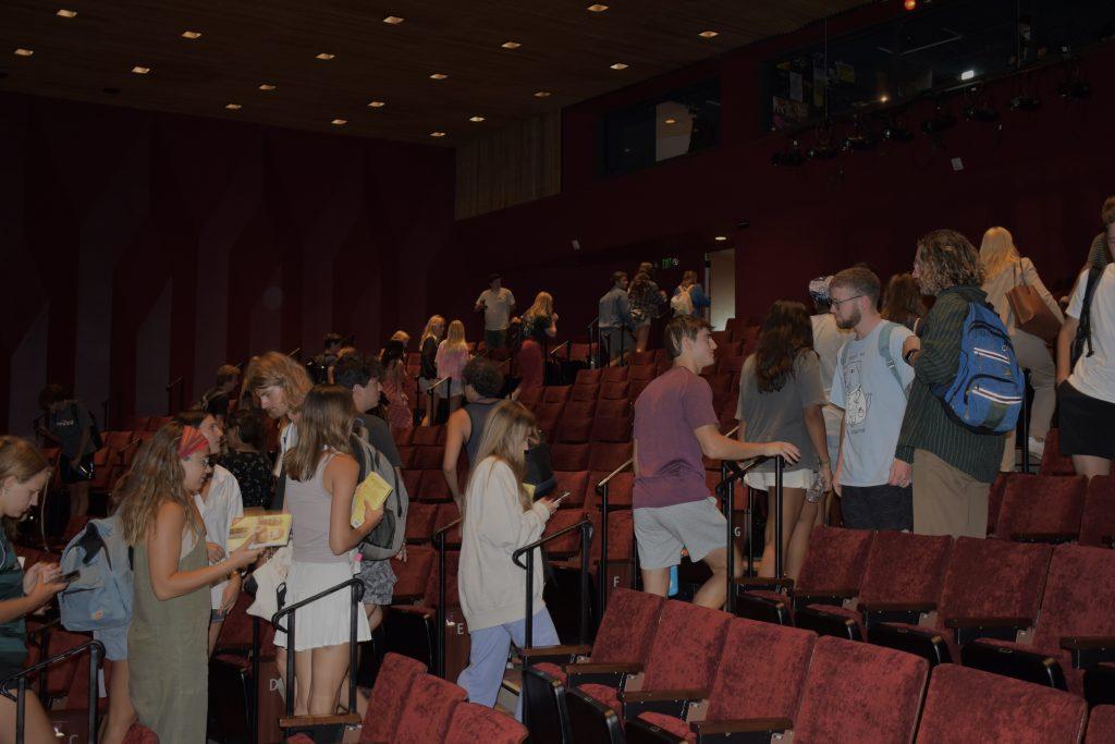 Seaver students are shown exiting the theater with copies of the book "Divine Collision" at the end of the screening on Aug 30. Gash and Tumusiime wrote a book about their experiences and journey together. Photo by Mary Elisabeth