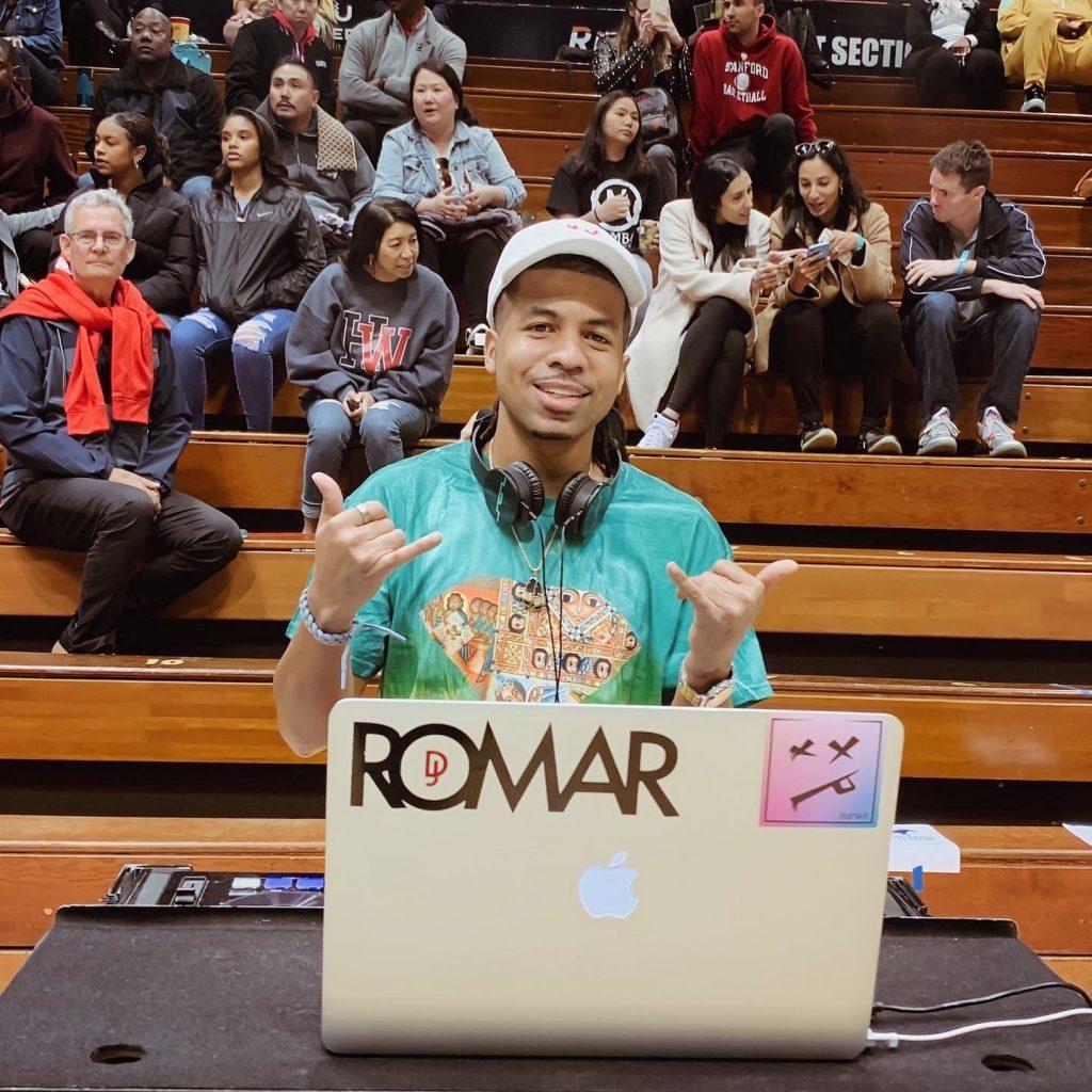Romar positions himself before a game at Firestone Fieldhouse. With Romar facing the court and unable to see the reactions of the fans, Romar said he listens to the crowd to mix the beats during the game.