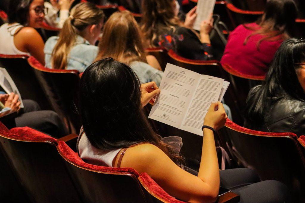 An audience member in Smothers Theatre looks over a "Pride & Prejudice" program before the production Oct. 4. The cast of the play featured only six members.