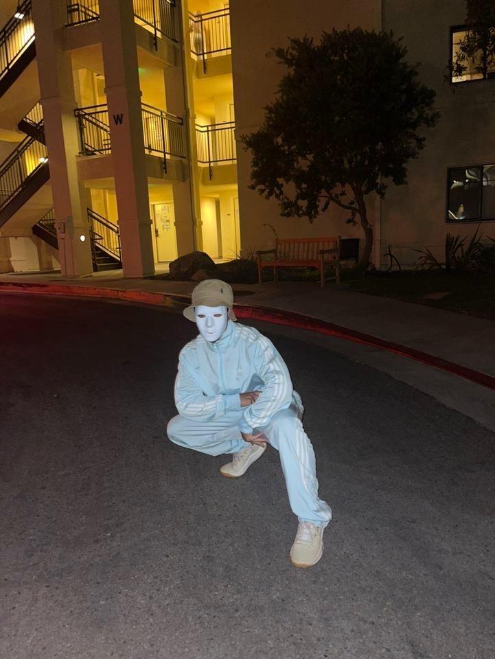 Junior Devin Cooke poses on campus Oct. 20. He wore his Jabawockeez mask in a blue Adidas tracksuit. Photo courtesy of Devin Cooke