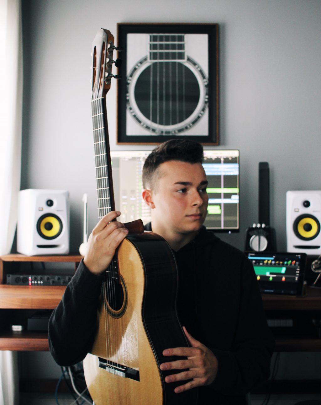 Nolan Harvel poses in his home studio with his guitar last year. Surrounded by speakers, a monitor and other instruments, this is where Harvel said he first started writing his own music. Photo courtesy of Nolan Harvel