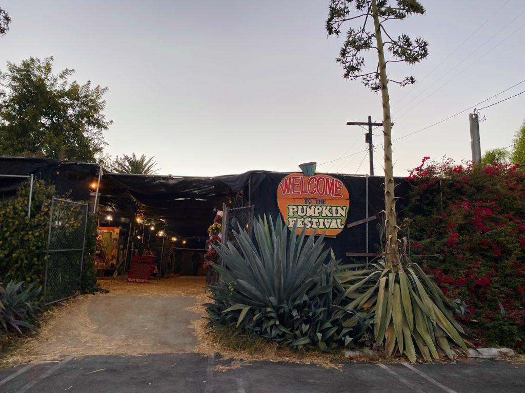 Adjacent to the Toluca Lake Flower shop, the Pumpkin Festival sports a painted sign outside the parking lot to welcome guests into the event Sept. 30. Toluca Lake Flowers has hosted the Pumpkin Festival for 32 years in North Hollywood. Photo by Emma Ibarra