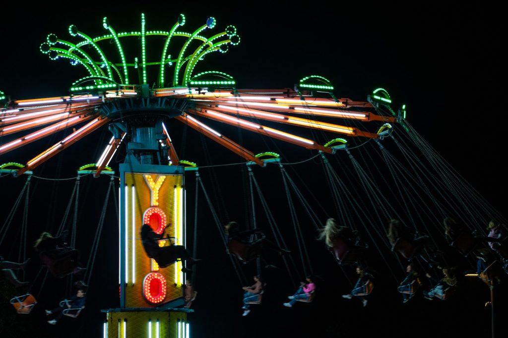 Students and family members enjoy the swings at Madness Village on Oct. 14. Other  games and food continued through the night until 8 p.m. Photo by Brandon Rubsamen