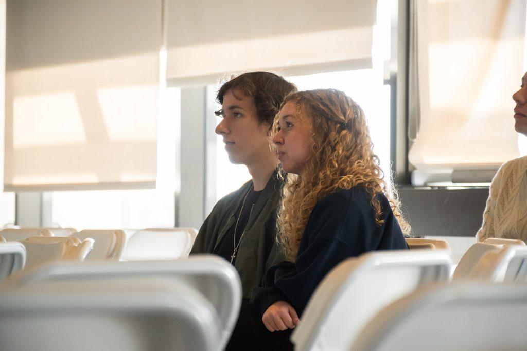 Juniors Colin Wiese and Jacey Hoy watch the candidate presentation Jan. 11. Wiese said he came to learn more about Dinani, a candidate he has not met previously.