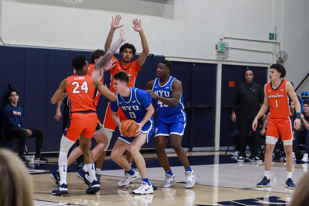 Pepperdine Men's Basketball sophomore forward Maxwell Lewis and Porter surround BYU freshman guard Tanner Toolson on Feb. 9, at Firestone Fieldhouse. The Waves held the Cougars to 21% shooting from 3-point range.