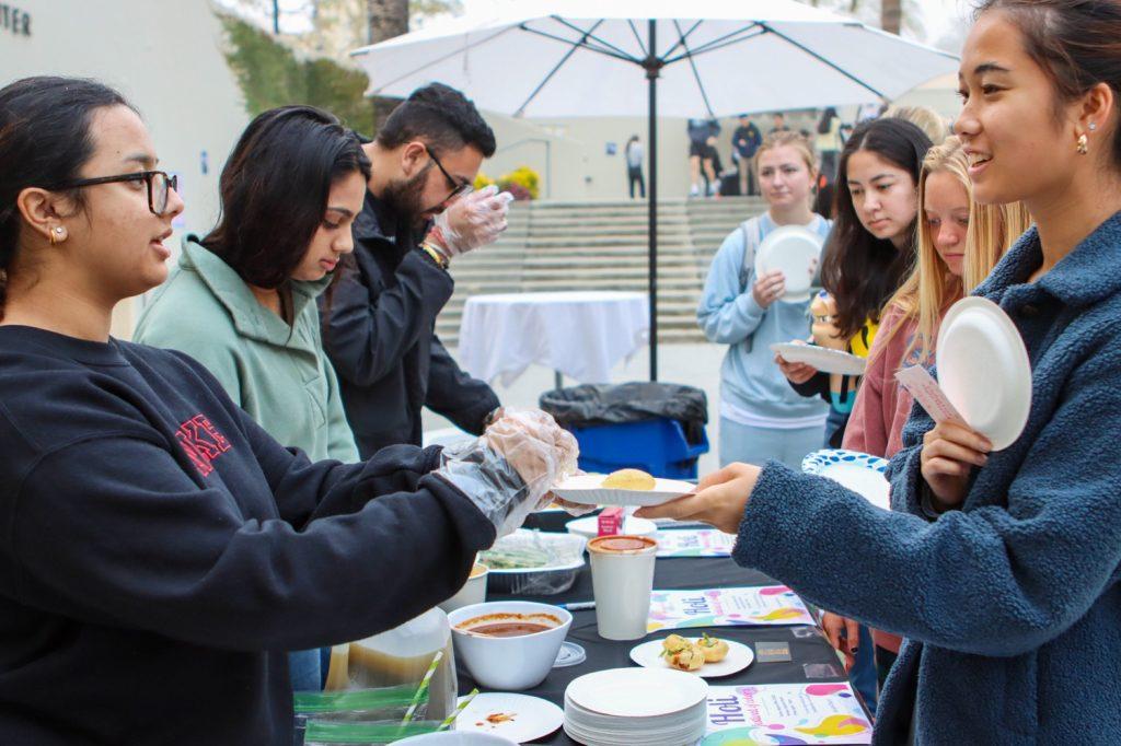 Students sample traditional Indian street food at the Global Fest Night Market on March 11. The Indian Student Association was one of seven clubs that tabled at the Global Fest Night Market, Jingkaojai said.