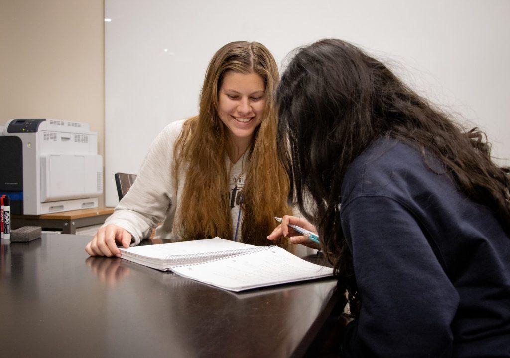 Allison Hilliard tutors a student in the evening at the Student Success Center. Although the hours are late, she said the sacrifice was worth it.