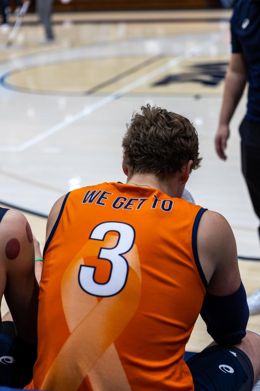 Cole sits on the bench during a break in gameplay at Firestone Fieldhouse on March 9. Cole approaches volleyball with a sense of gratuity, evident by the writing on the back of his jersey: "WE GET TO." Photo by Brandon Rubsamen