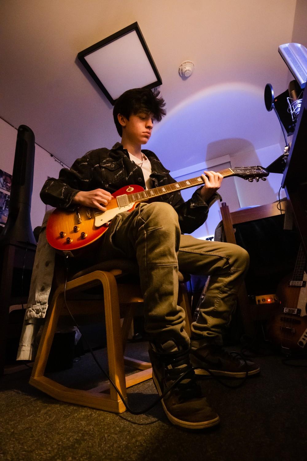 Sophomore Evan Herrera plays his guitar at Seaside Residence Hall.