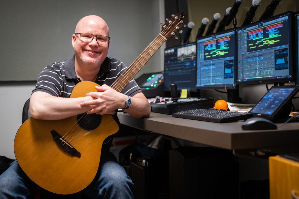 Scott Woeckel in the Caruso School of Law with his guitar, Woeckel has a degree in Ethnomusicology and always dreamed of being a musician, he said.