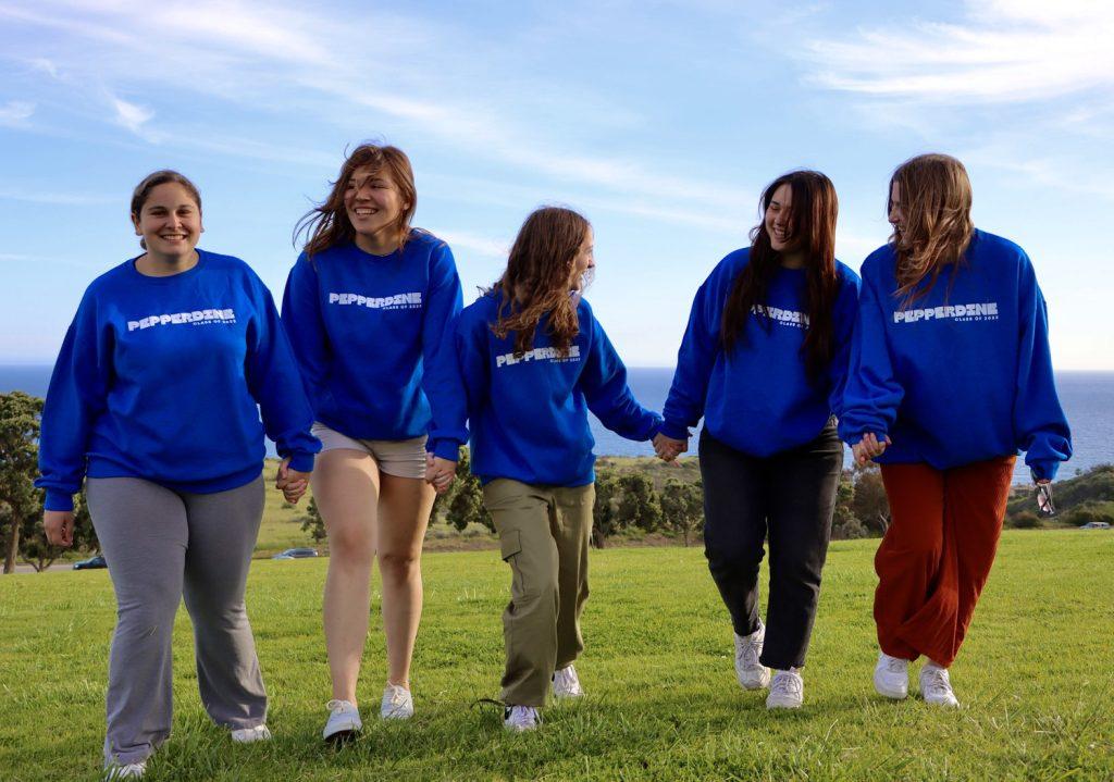 Seniors and friends pose for a picture with their new senior sweatshirts at Senior Sunset on Alumni Park on April 7. SGA passed out these class sweaters as students checked in for the event.