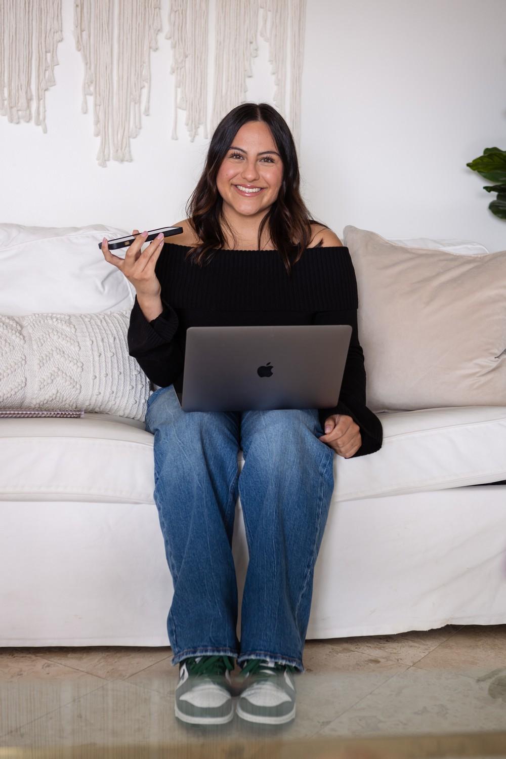 Hurtado poses for a picture with her laptop and phone. She said her parents encouraged her to embrace her authenticity, and she wanted to create a platform where she could be vulnerable and others could relate to her.