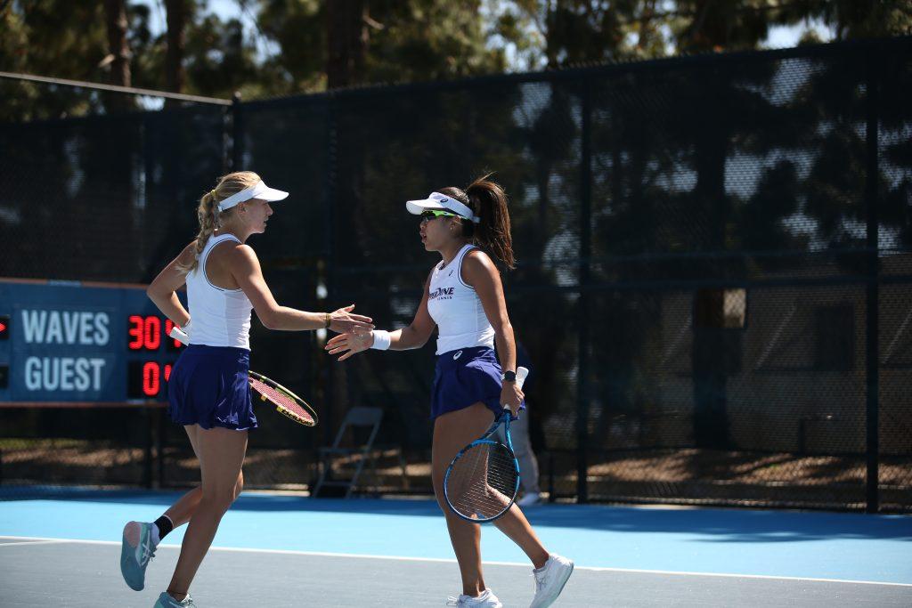 Bunyawi Thamchaiwat and Lisa Zaar congratulate each other after they win a point against University of Oklahoma's 17th-ranked doubles team at the Ralphs-Straus Tennis Center on March 24. The duo earned a 6-4 win to give Pepperdine an early lead in the match, according to Pepperdine Athletics. Photo courtesy of Pepperdine Athletics