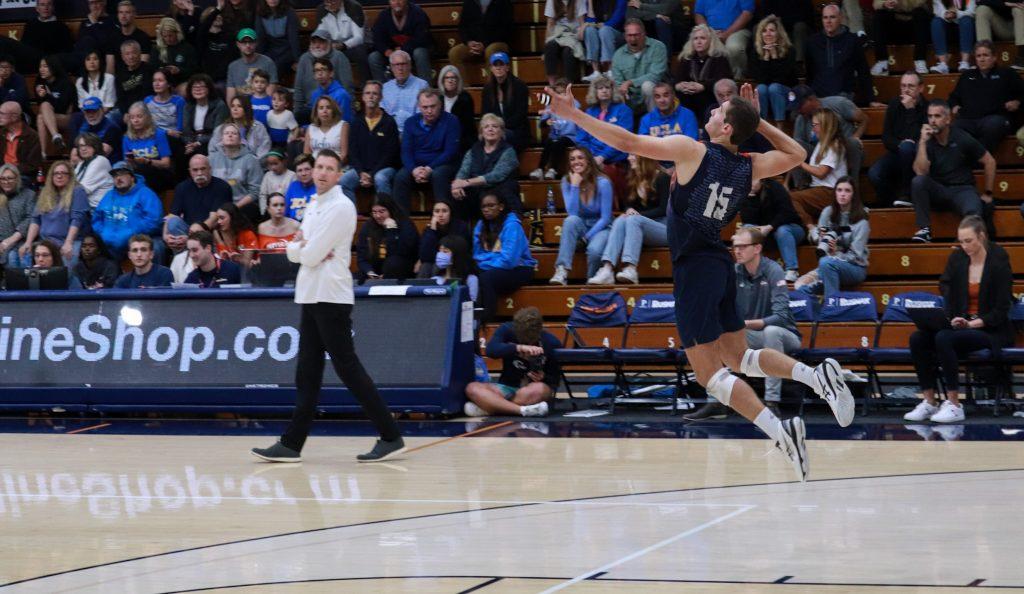 Player on Waves Mens Volleyball team serving the ball in Firestone Field house