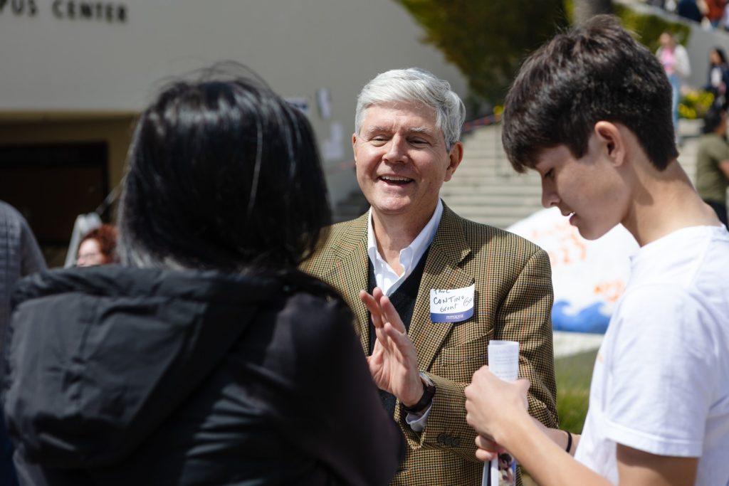 Paul Contino, professor of Great Books, speaks to a family on Lower Mullin Town Square on March 31. Students said meeting with professors helped them learn more about the University.