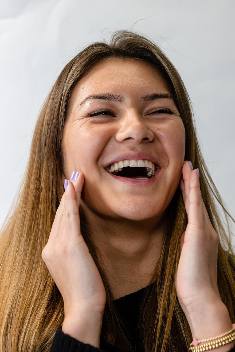 Lily Vu laughs while applying Sonya Dakar serum. Vu said the serum is her favorite skin-care product.