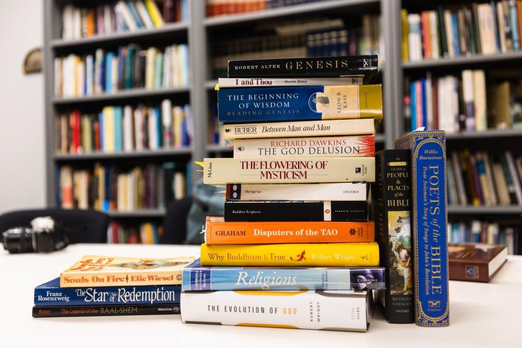 A stack of books about world religions sit on a desk in a Pepperdine office.