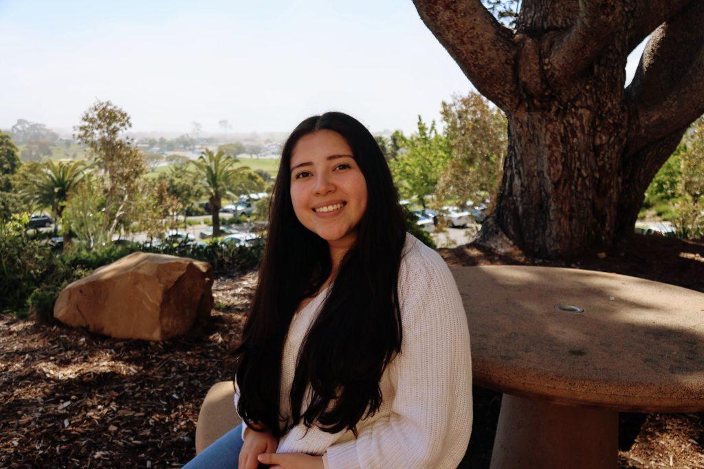 Senior Stephanie Abad sits outside Firestone Fieldhouse on April 10. At one point, Abad said she never thought going to college was a possibility and is excited to graduate in April. Photo by Emma Ibarra