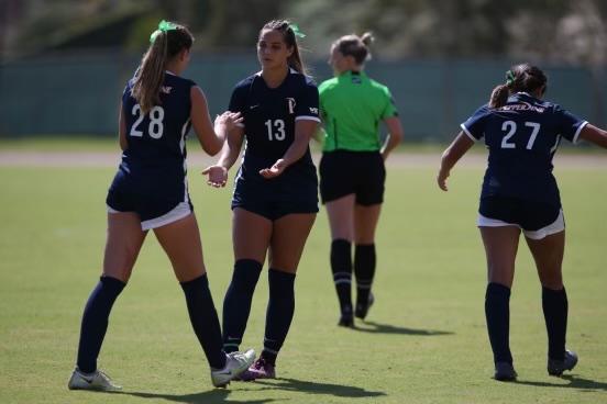 Freshman midfielder Tatum Wynalda high-fives redshirt senior defender Trinity Watson at Tari Frahm Rokus Field during a match in the fall 2022 season. During her five seasons with the waves, Watson recorded 44 points. Photo courtesy of Tatum Wynalda