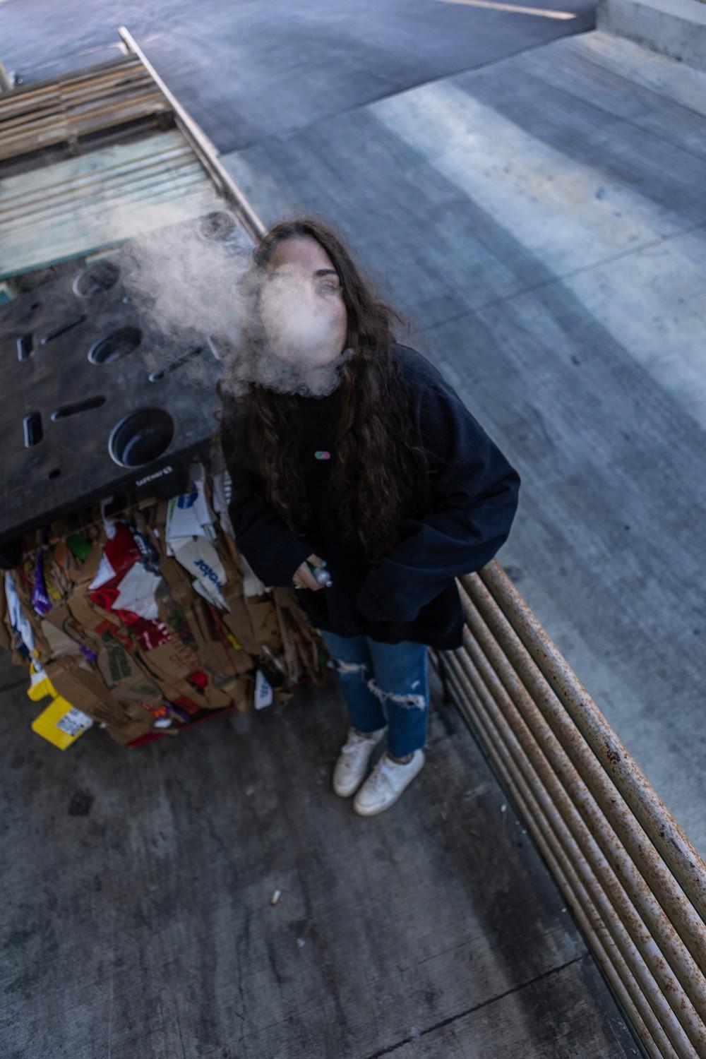 A student blows a cloud of vape toward the camera. Pepperdine Alumnus Steven Corvatta said vape companies mark vapes as 5% nicotine, which is an insane amount for someone to take in.