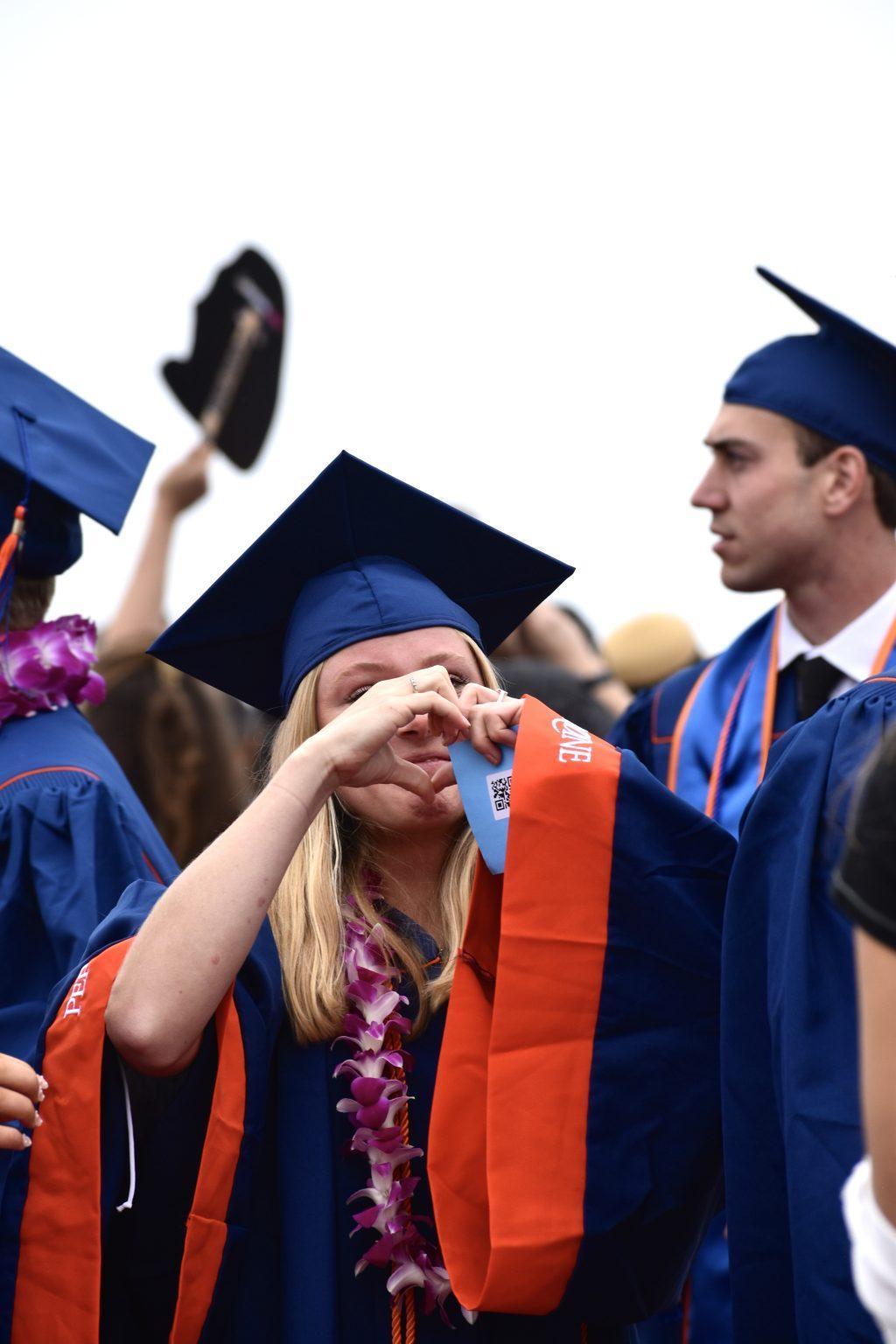 A Seaver college graduate holds up a hand heart to her family cheering her on from the crowd. The commencement ceremony was nothing less than emotional.