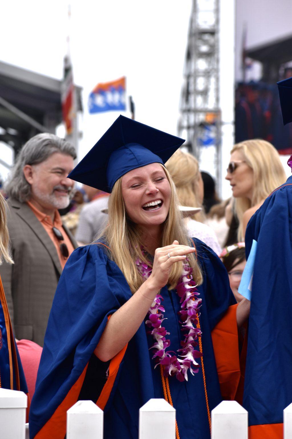 A graduate smiles with tears in her eyes after she finds her family cheering her on in the crowd. Families traveled from all over to celebrate the Seaver College Class of 2023.