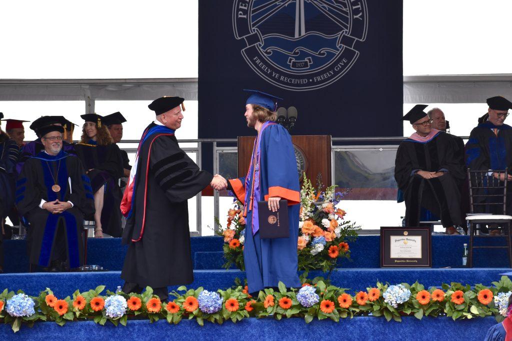 Graduate Jacob Seals shakes the hand of Dean Feltner after receiving his diploma. Seals graduated with a Bachelor of Science in Sports Medicine.