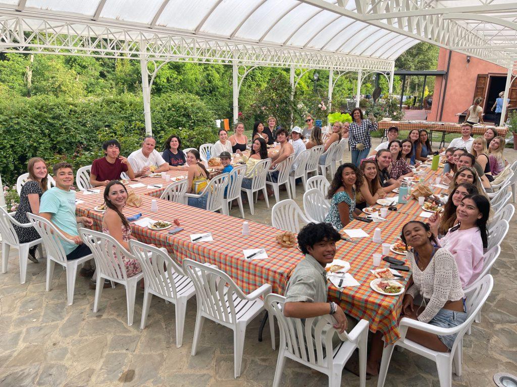 Florence summer 2023 students share a meal with President Jim Gash and First Lady Joline Gash at program director Elizabeth Whatley's house in Florence, Italy on June 20. Whatley opened up her residence in the Tuscan countryside for a night of festivities, which included a water balloon fight, a home-cooked meal, s'mores and a zumba class.