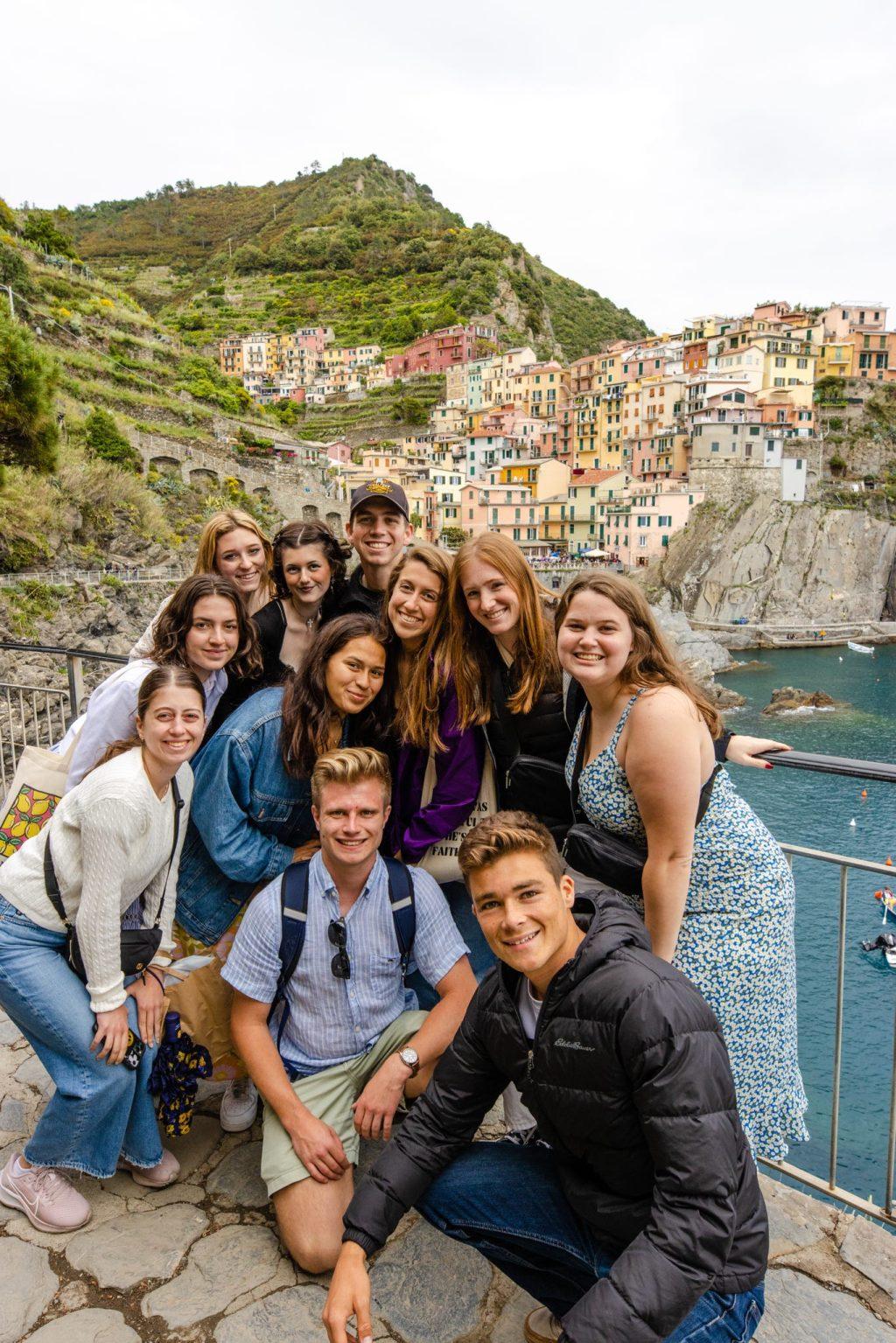 D'Andrea poses in front of the seaside village of Manerola with a group of Florence summer 2023 students in Cinque Terre, Italy on May 20. Cinque Terre translates to Five Lands, and students took a ferry boat to see each port.