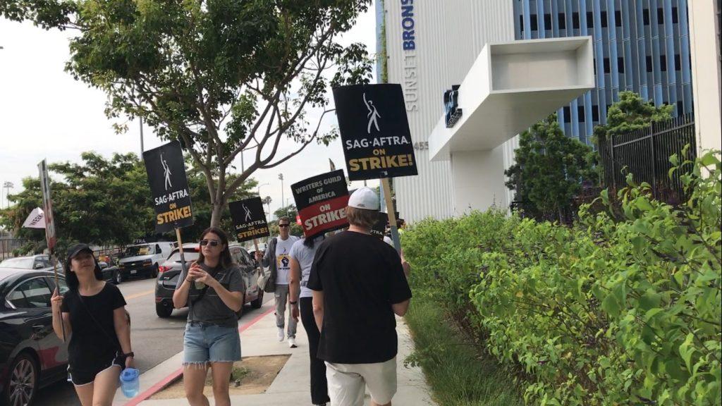 The WGA and SAG-AFTRA unions are striking in front of Sunset Bronson Studios in Los Angeles on Aug. 10. They're fighting for better pay and protections against AI.